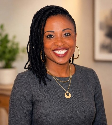 Portrait of Elizabeth Bristow, MSN, APRN, PMHNP-BC, smiling, wearing a grey top and gold necklace.